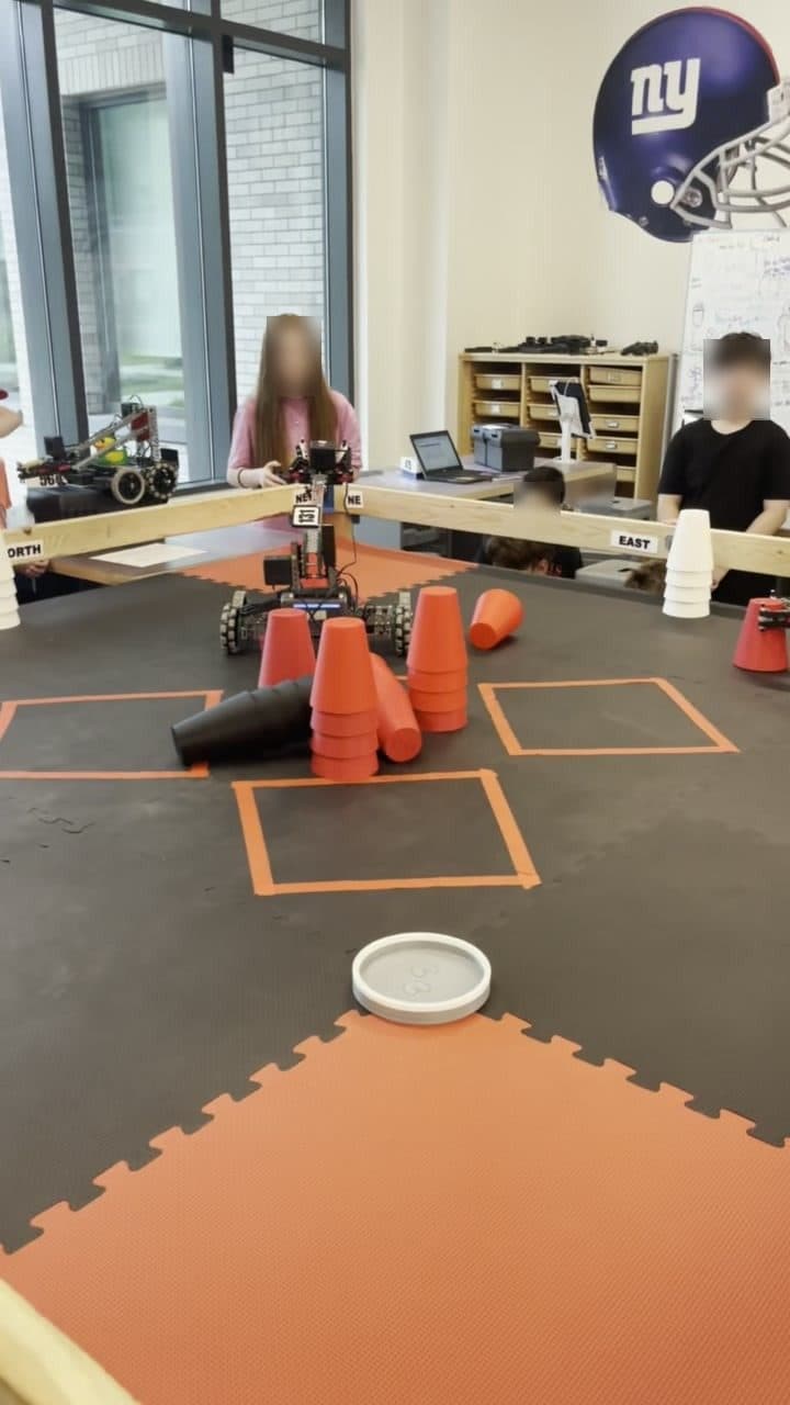 A robot stacking cups on a scoring plate