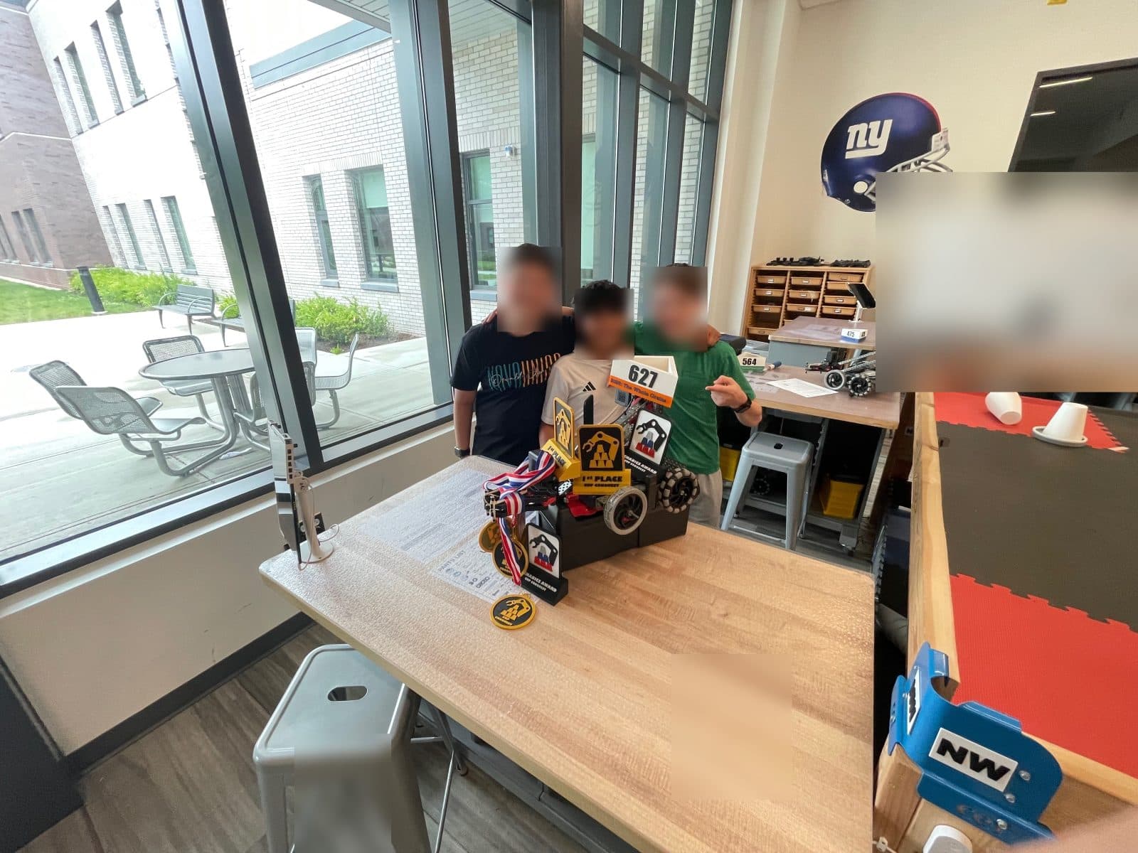 A team celebrating with their robot and trophy